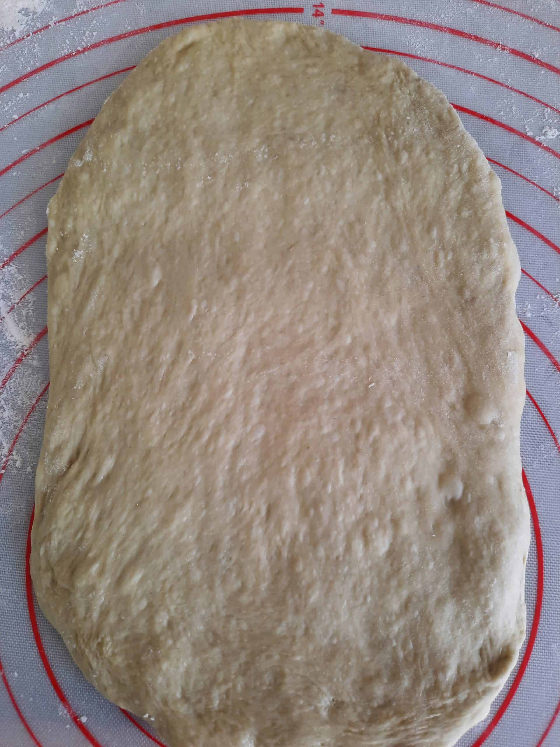 撒上手粉後，拍打麵團成略寬狀。 用擀麵棍往下、往上擀開。  從上往下將麵團捲起，完成擀捲 1After dusting with hand flour, pat the dough slightly wider. Use a rolling pin to roll down and up.   Roll up the dough from top to bottom, finishing rolling 1 time. 次。