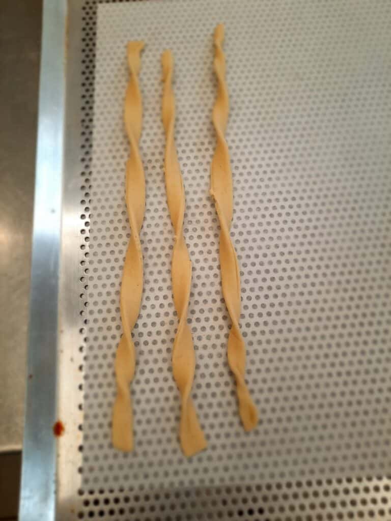 grab each dough strip at the 2 ends and twist them around each other's axis to give a twisted look